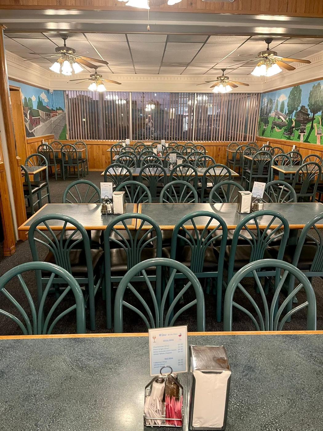The dining room at Grecian Steak House, with local scene murals on the walls